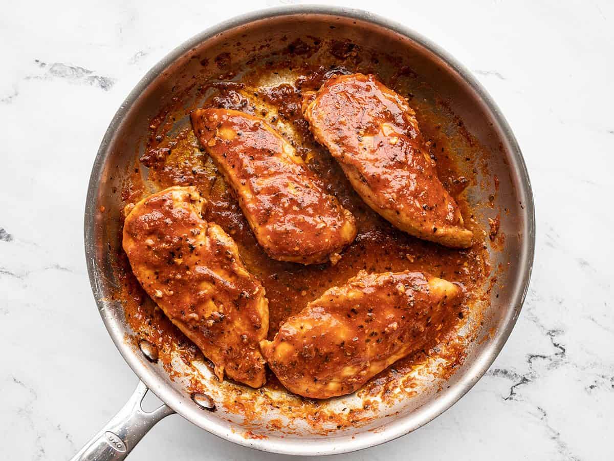 Chicken returned to the skillet and coated in sauce.