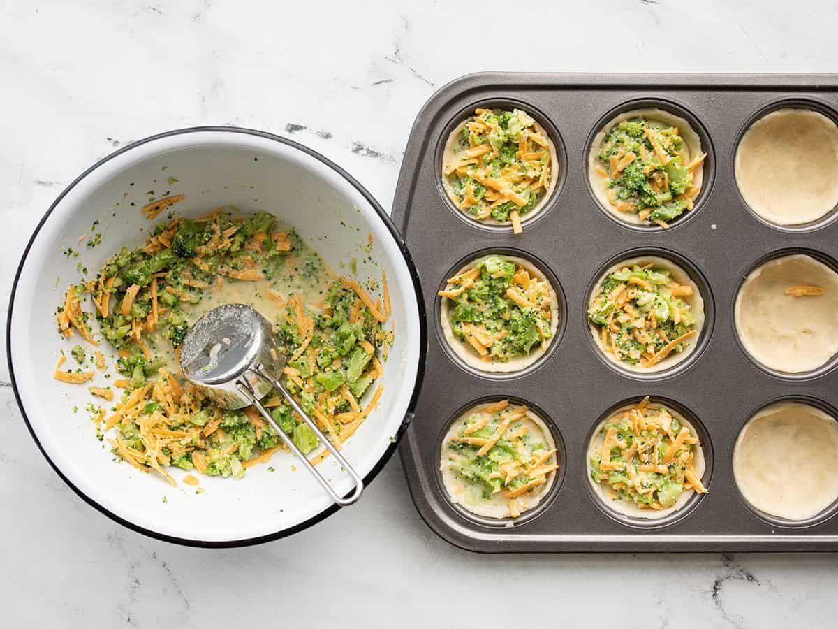 broccoli cheddar mixture being portioned into muffin tin.