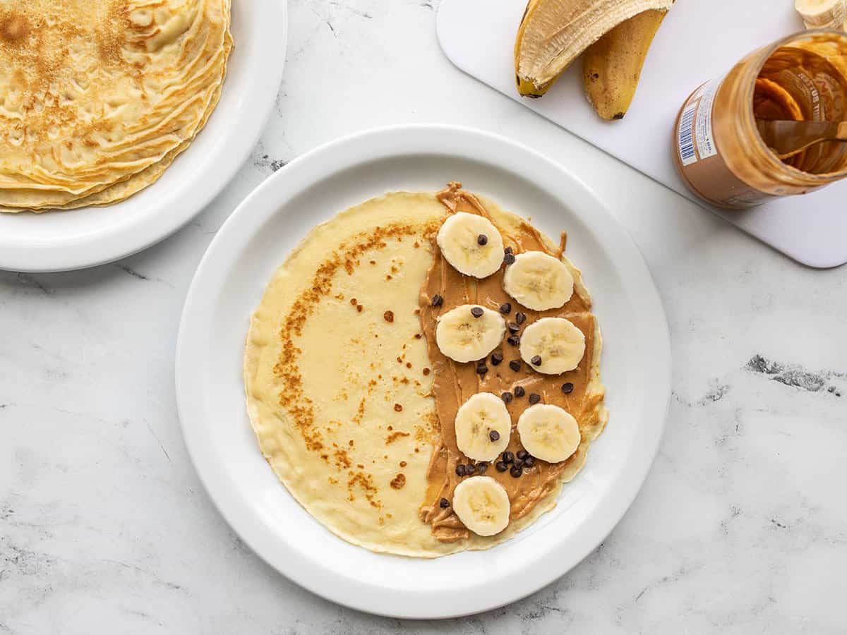 peanut butter, banana, and chocolate chips on a crepe.