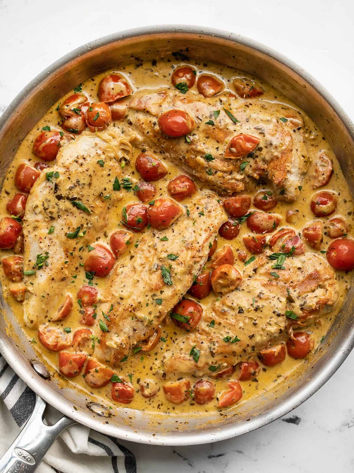 Overhead view of creamy pesto chicken in the skillet.