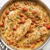 Overhead view of a skillet full of creamy pesto chicken.