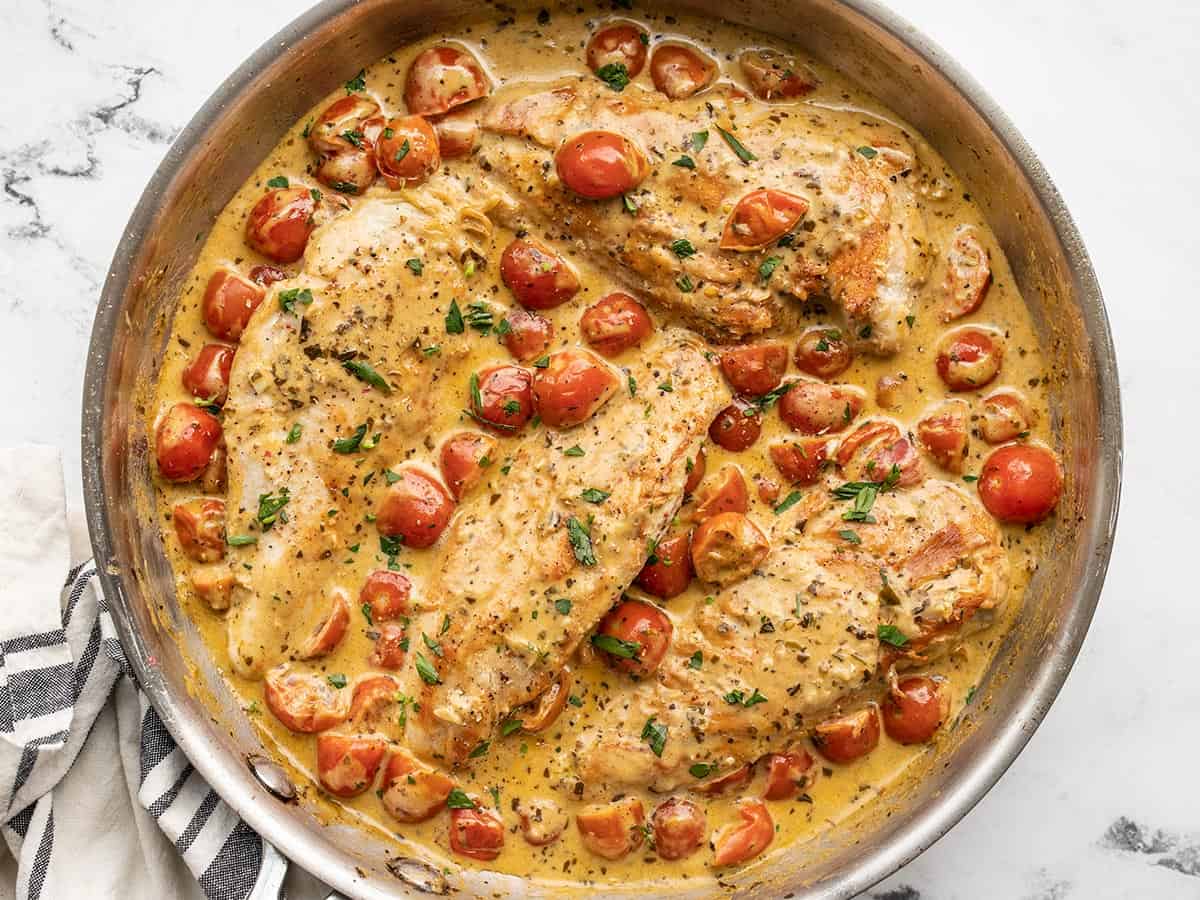 Overhead view of a skillet full of creamy pesto chicken.