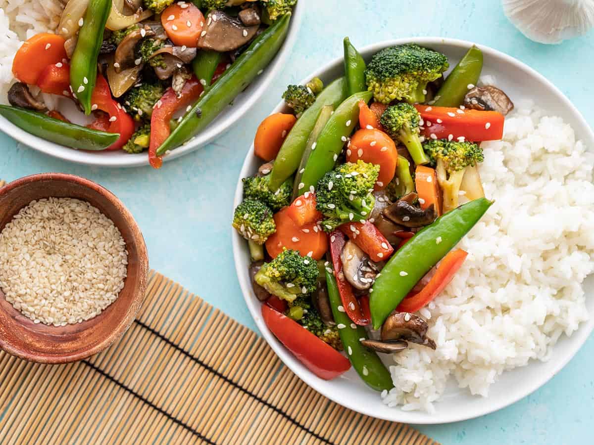 Two bowls with vegetable stir fry and rice