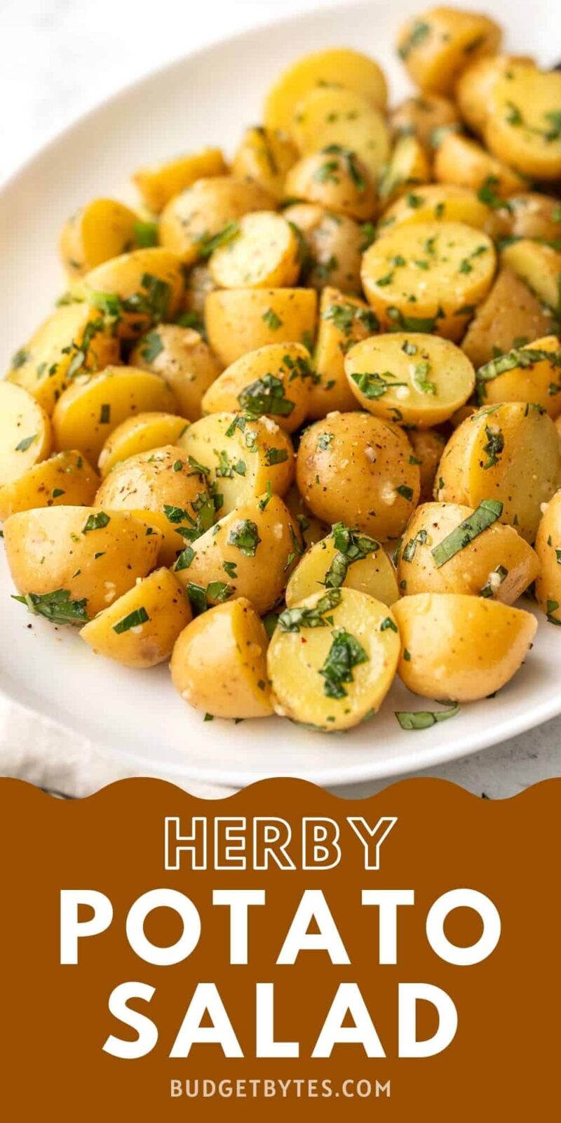 close up side view of herby potato salad on a platter.