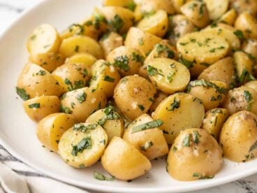 side view of a platter full of herby potato salad.