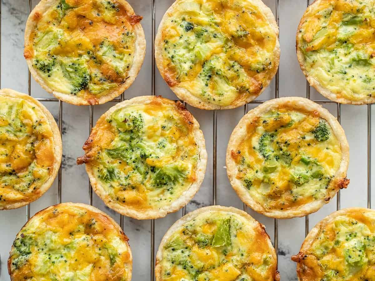 Mini broccoli cheddar quiches on a wire cooling rack.