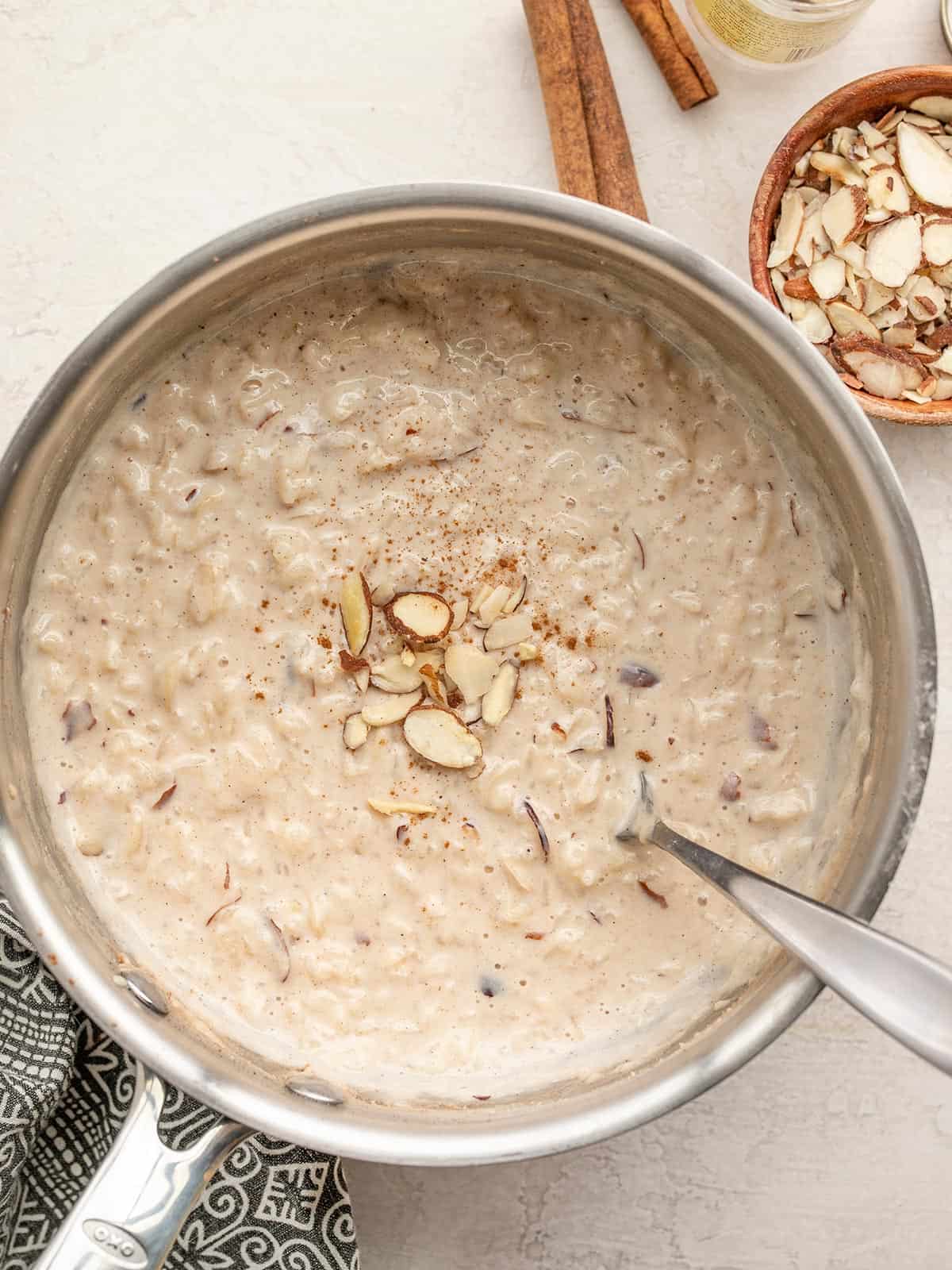 Rice pudding in a sauce pot topped with almonds