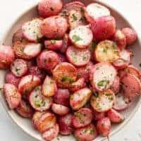 Overhead view of a bowl full of roasted radishes.