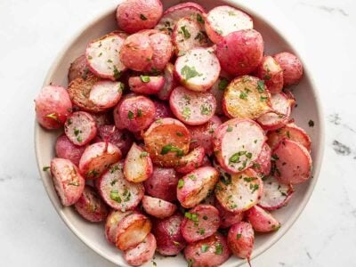 Overhead view of a bowl full of roasted radishes.