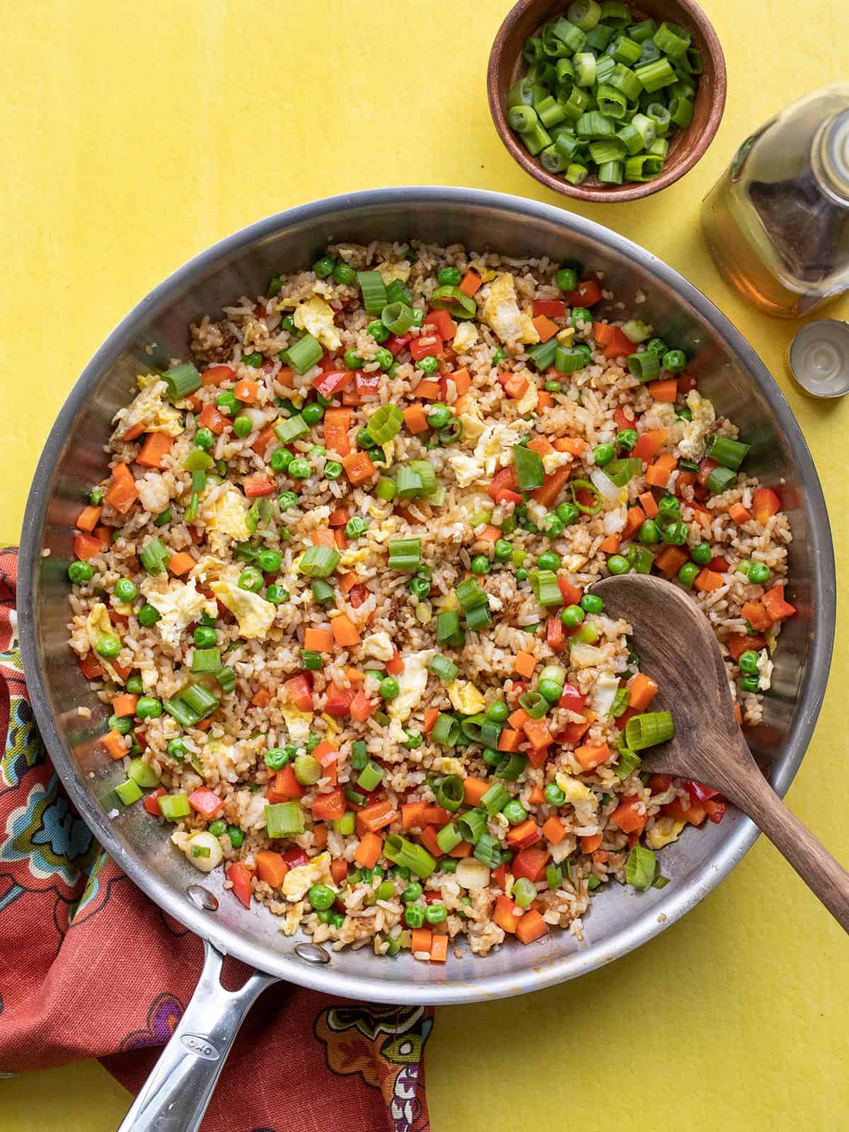 finished vegetable fried rice in a skillet against a yellow background.