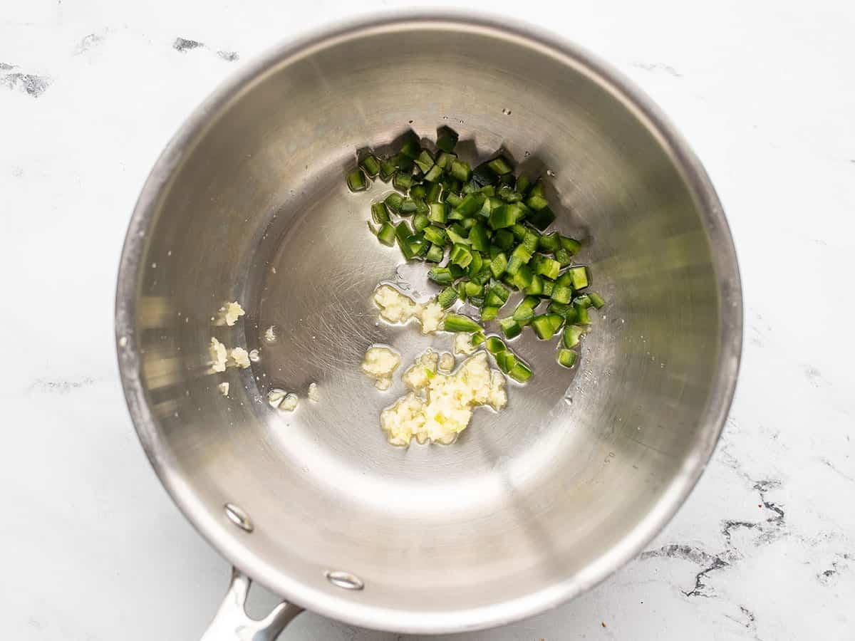 Garlic and jalapeño in a pot.