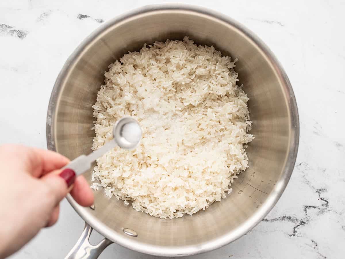salt being added to a saucepot with rice