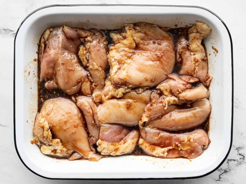 boneless, skinless chicken thighs in a shallow dish with marinade.