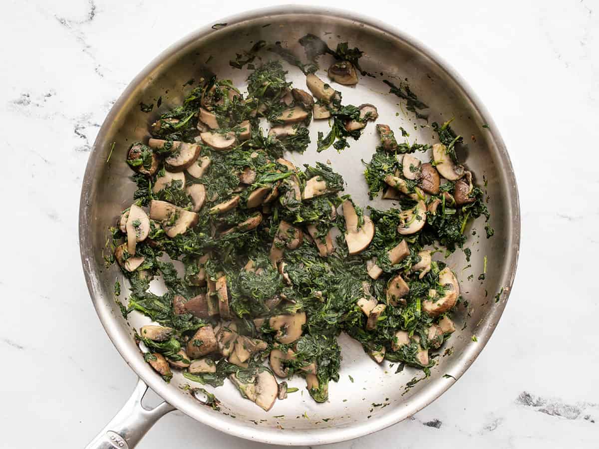 sautéed spinach in the skillet with the mushrooms