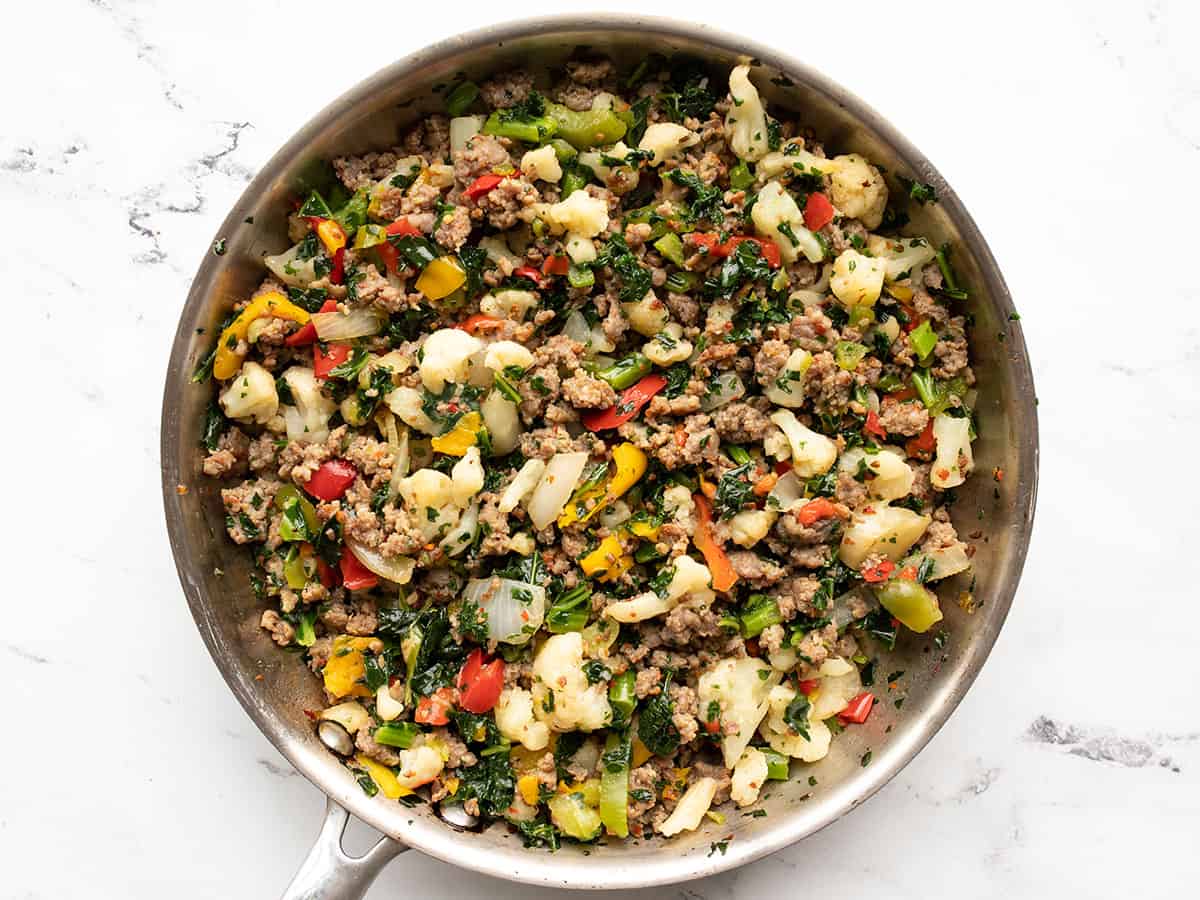 Cooked vegetables and sausage in the skillet.