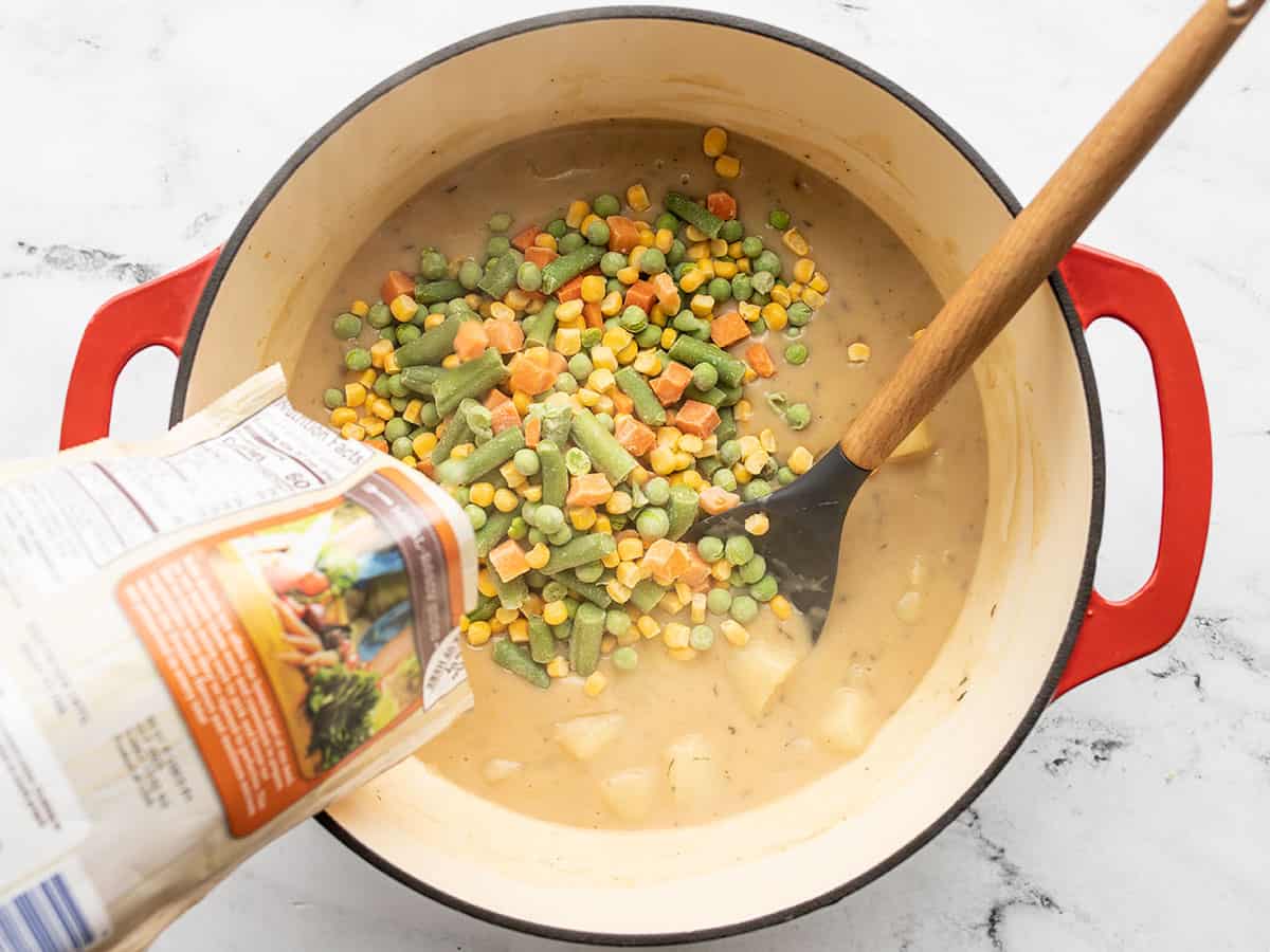 Frozen vegetables being poured into the pot.