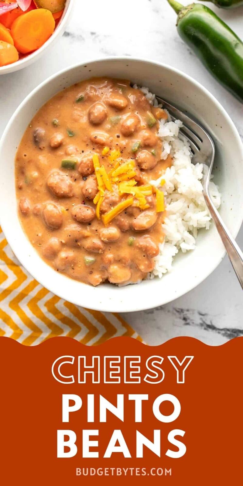 Overhead view of cheesy pinto beans in a bowl.