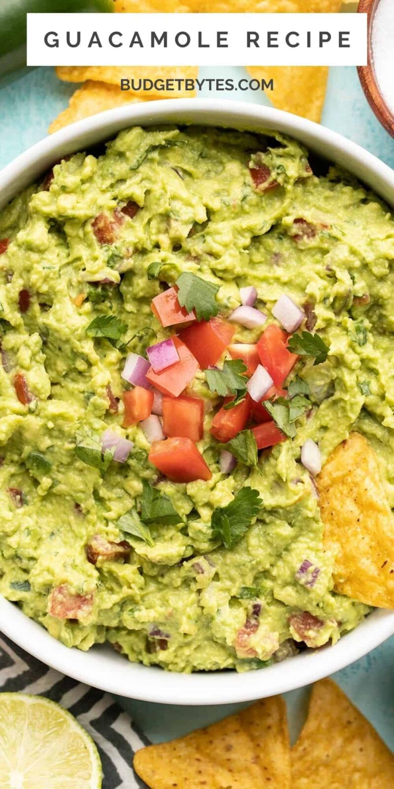 Close up overhead view of guacamole in a bowl with a chip.