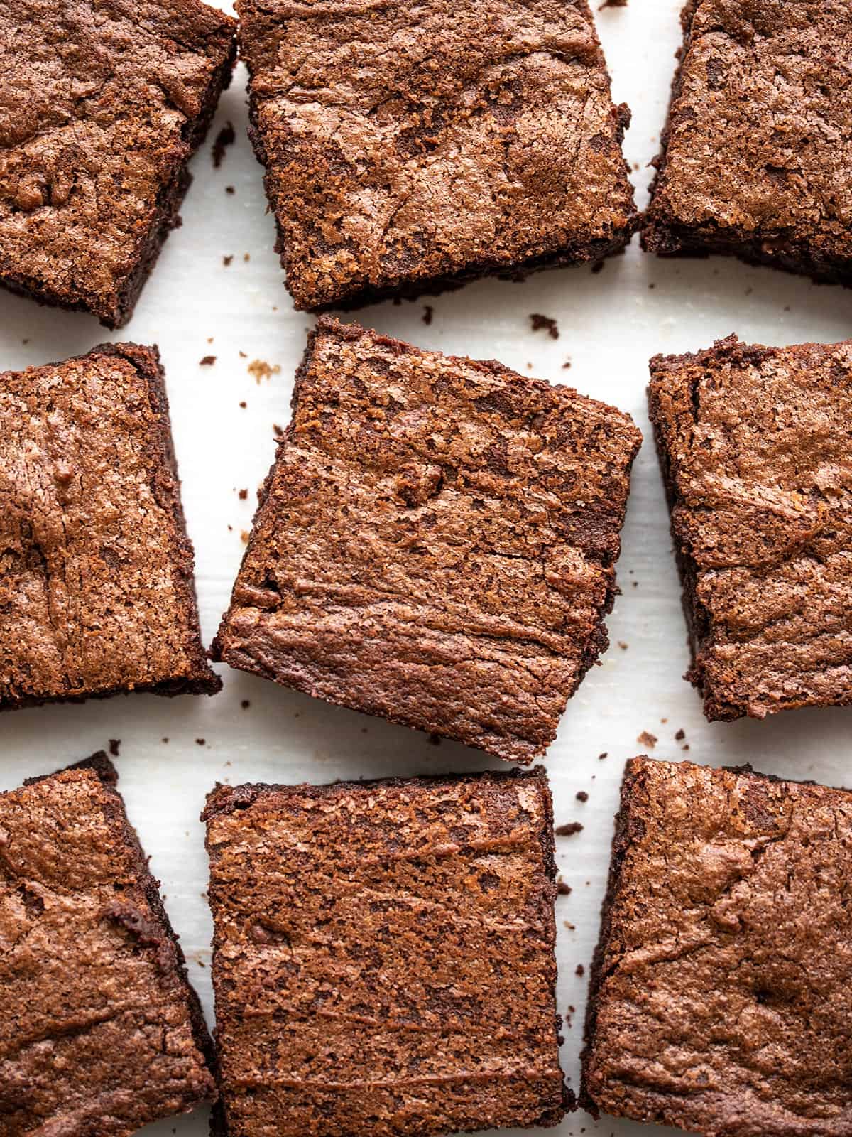 Homemade brownies scattered on a surface, from above.