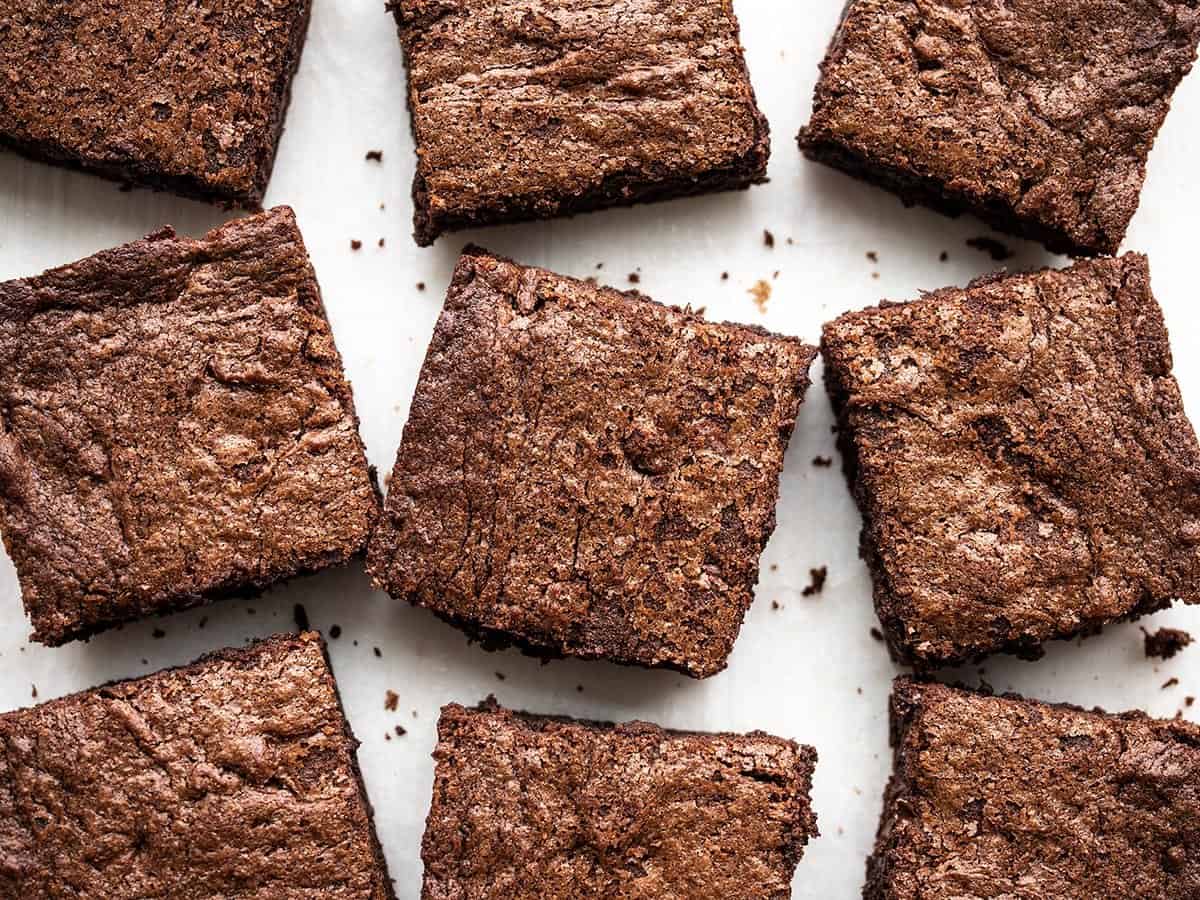 Overhead view of cut brownies scattered on a surface.