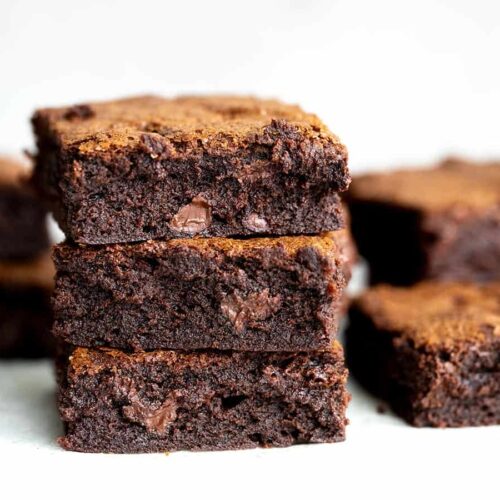 Side view of a stack of fudgy homemade brownies.