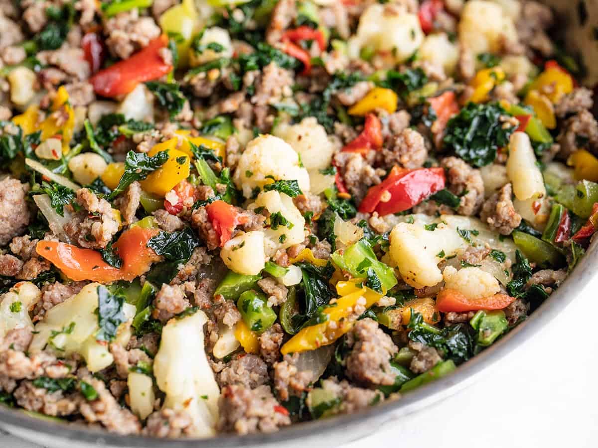 Side view of sausage and vegetables in the skillet, close up.