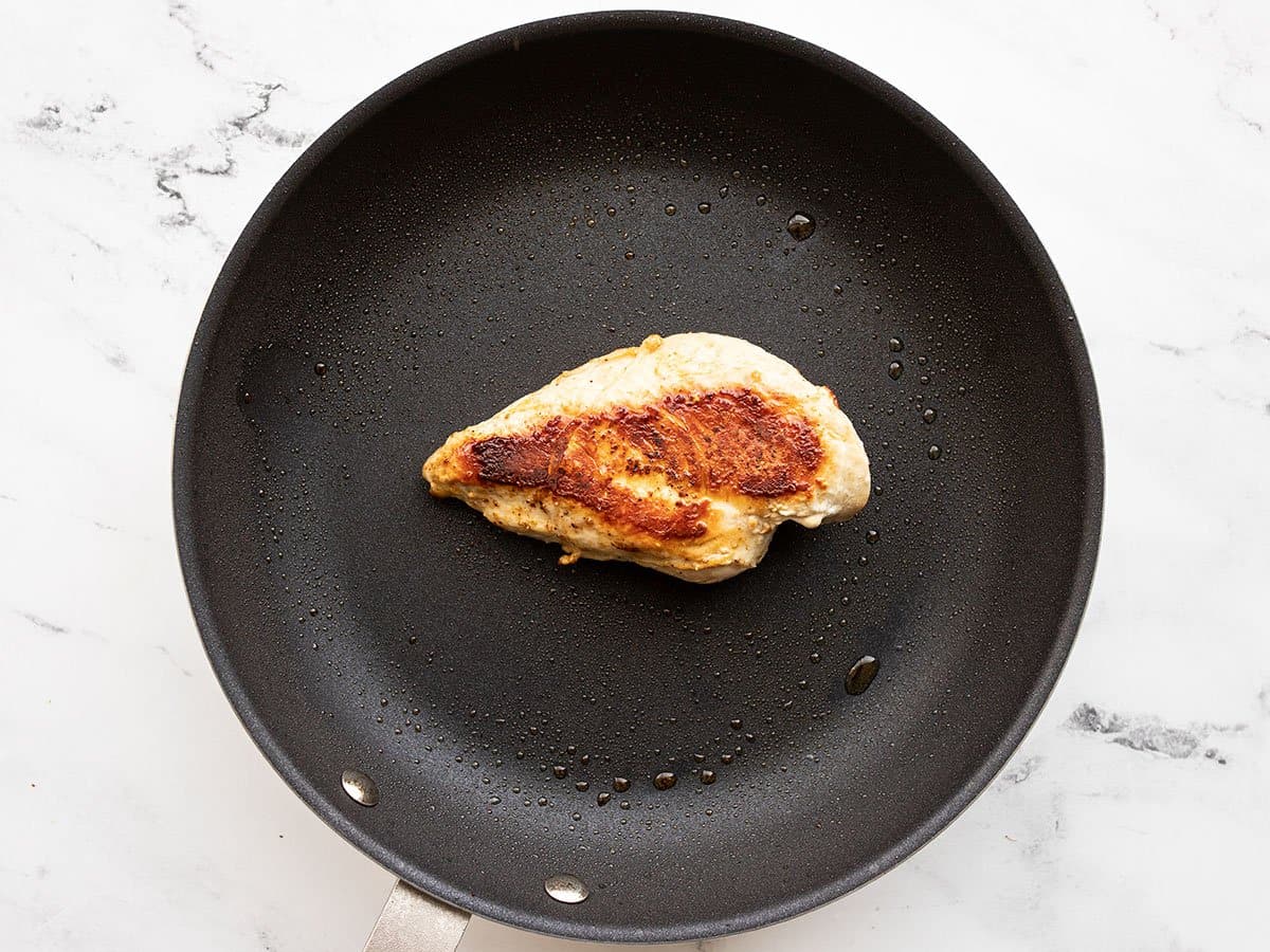 Cooked chicken breast in a skillet.