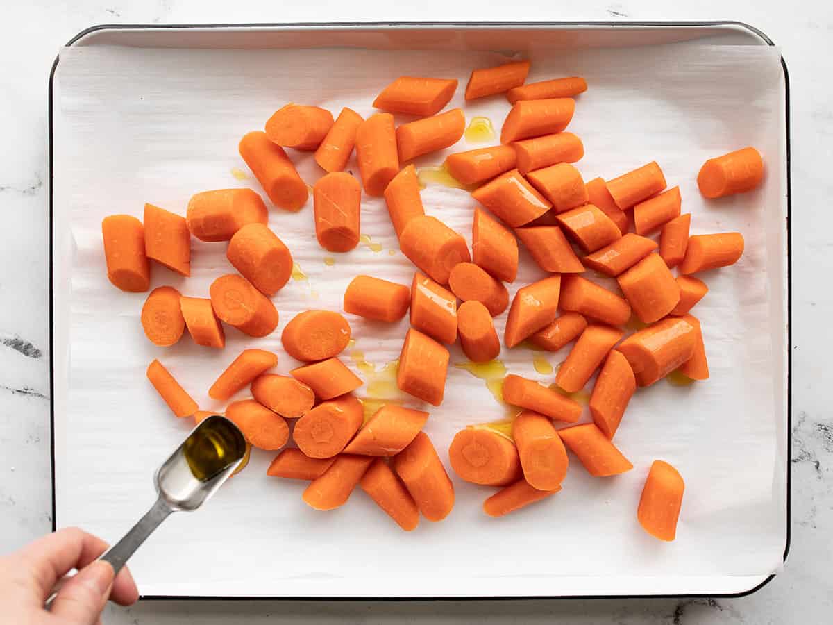 Sprinkle oil on the carrots on a baking sheet.
