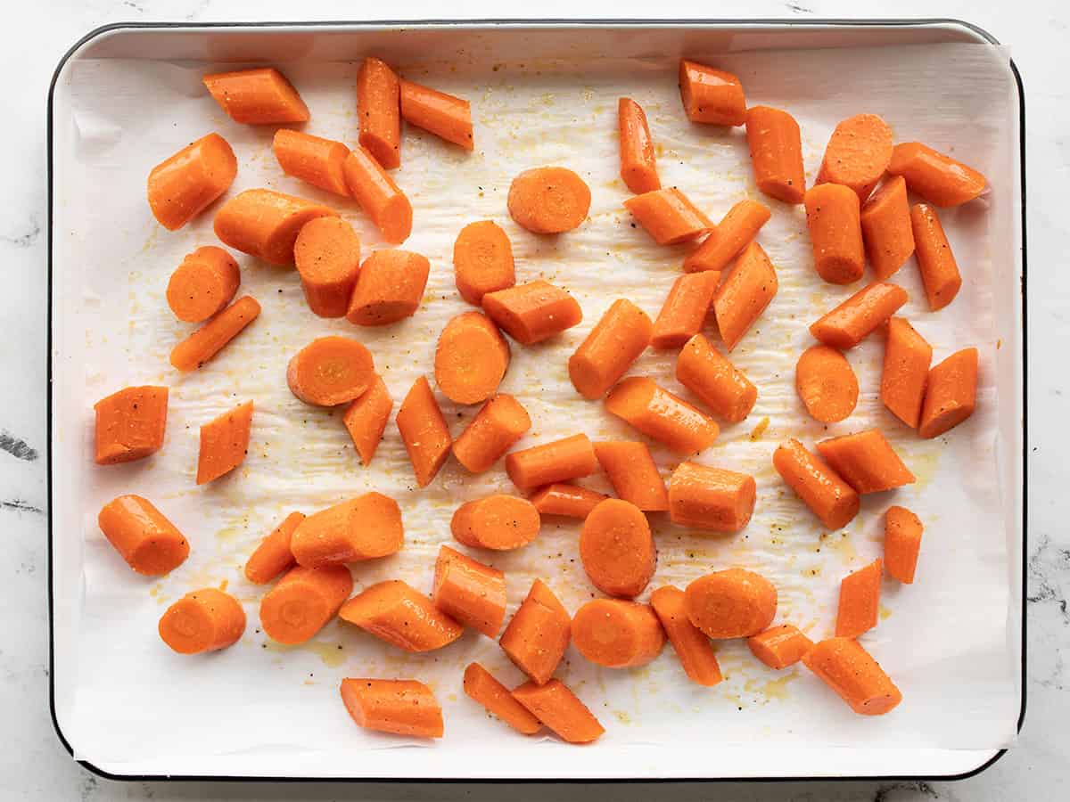 Seasoned carrots on a baking sheet.