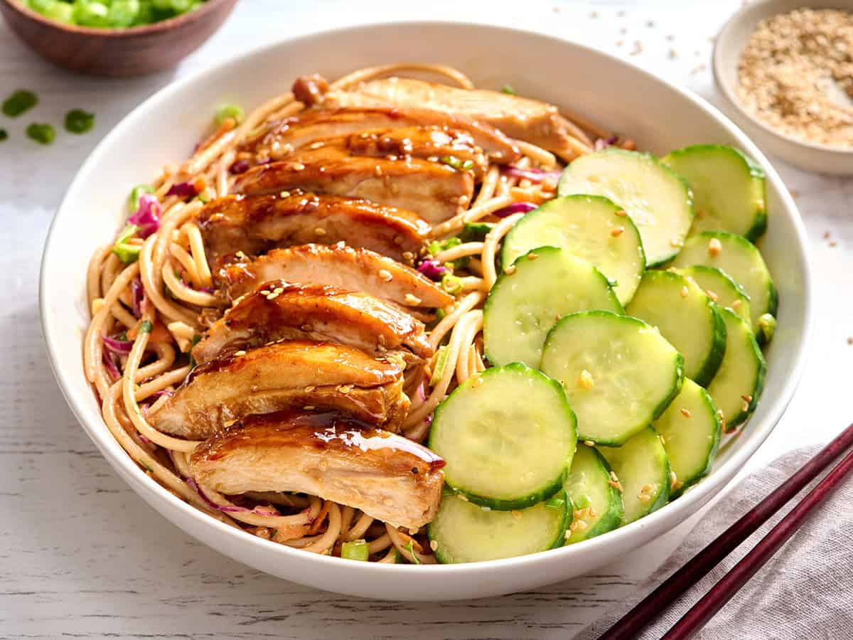 Teriyaki chicken on a cold noodle salad with a Thai cucumber salad.