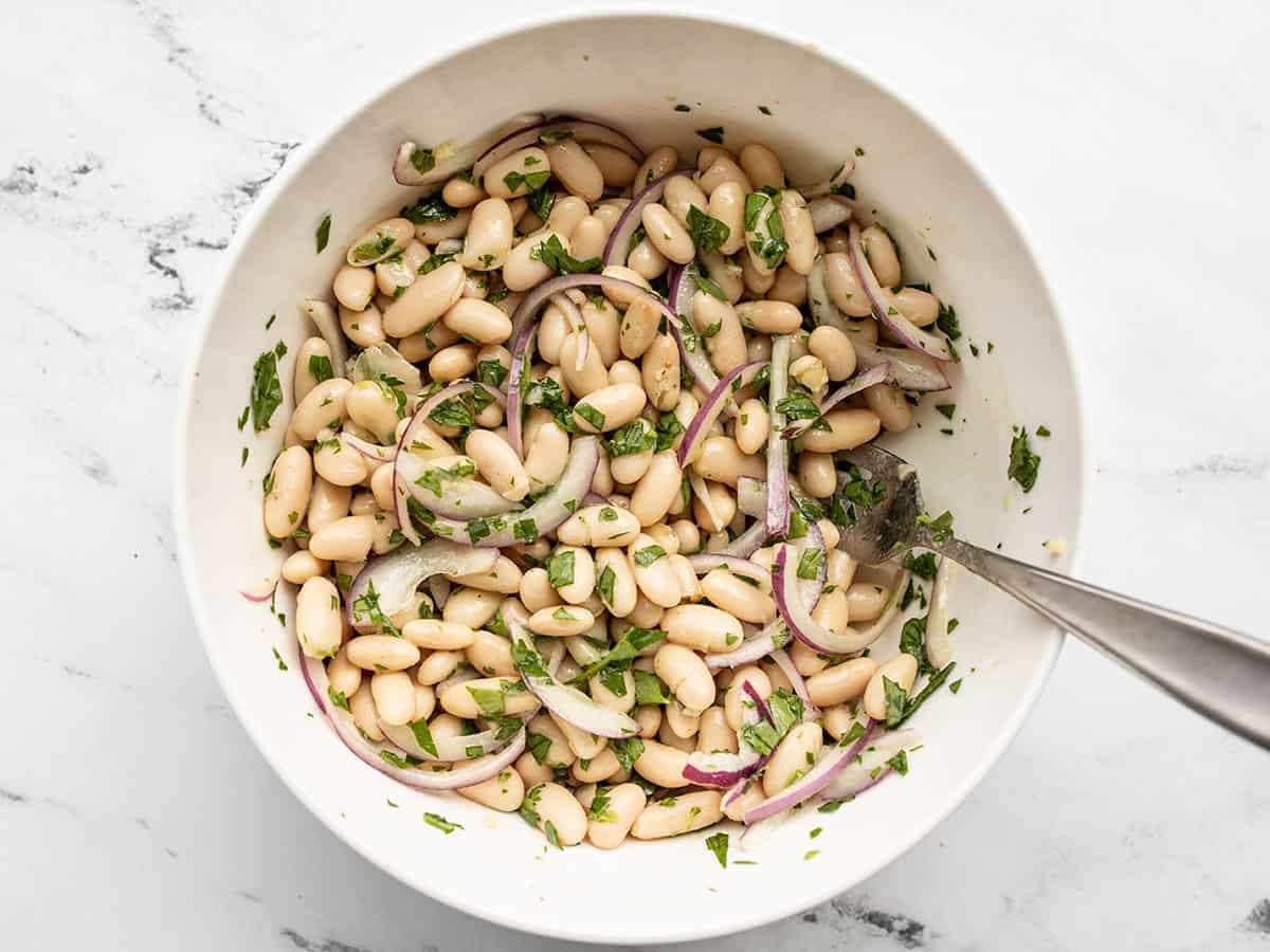 White bean salad stirred together in a bowl.