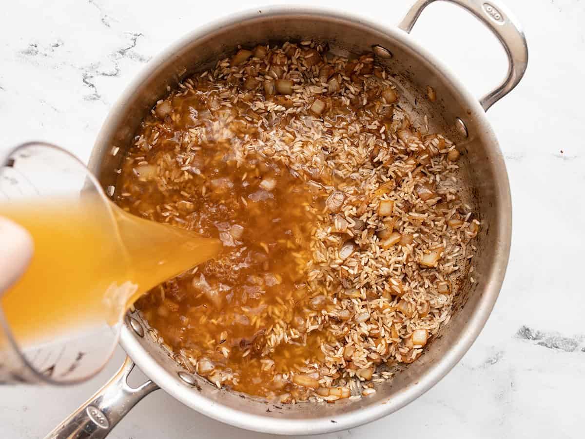 Broth being poured into the skillet.