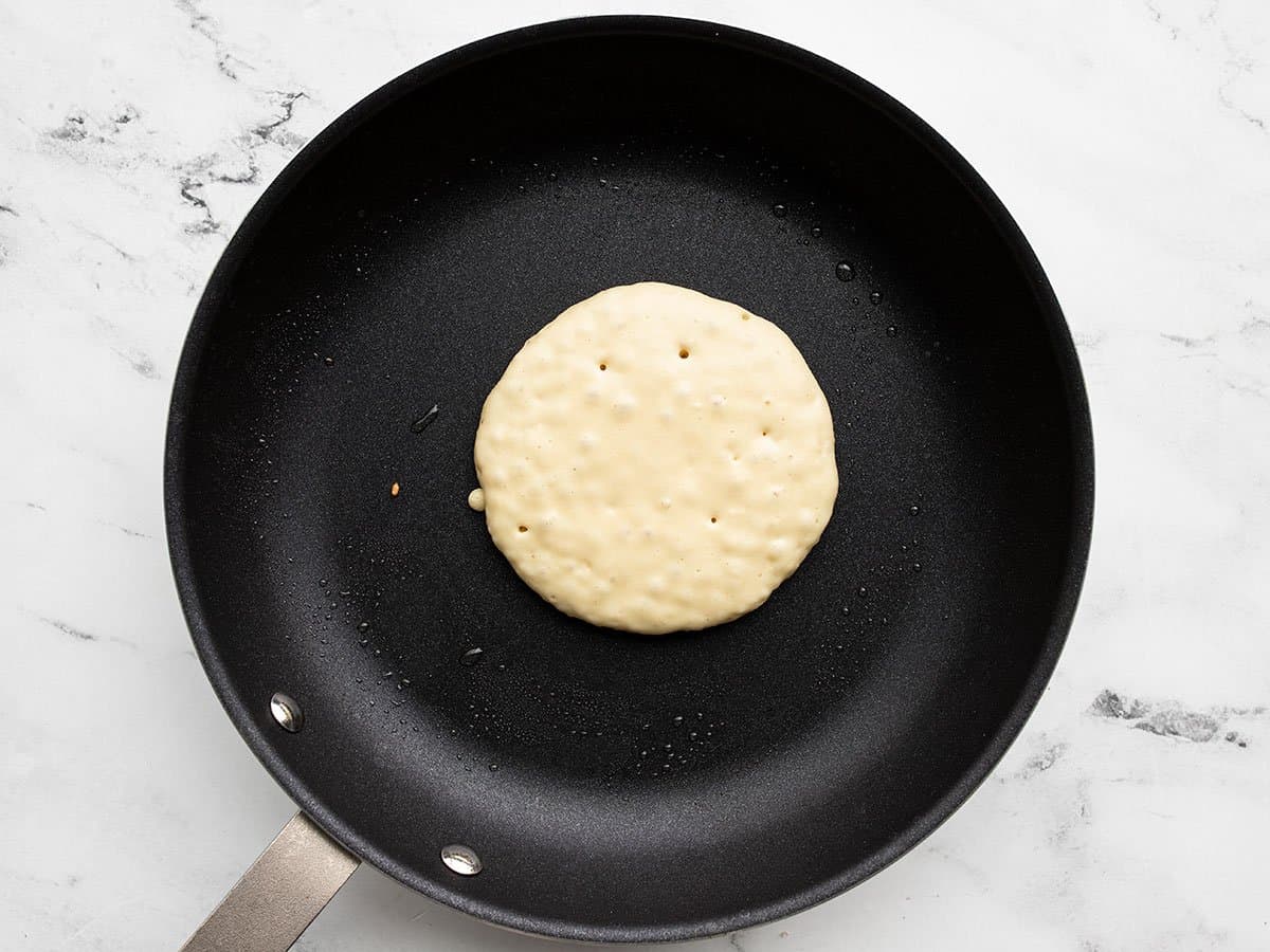 Half-cooked pancake in a pan.
