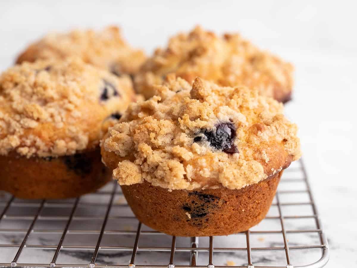 Side view of blueberry muffins on a cooling rack.