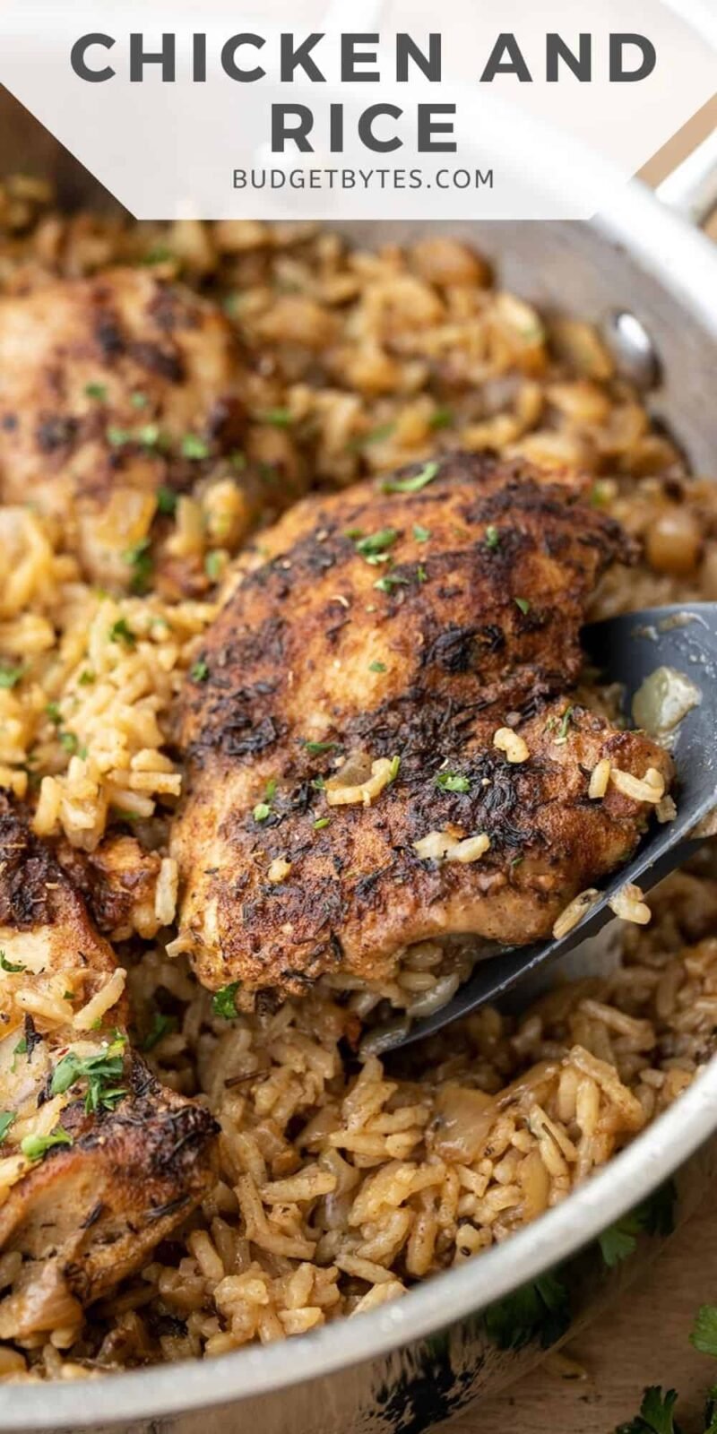 side view of chicken and rice being scooped out of the skillet.