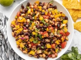 Close up overhead view of cowboy caviar in a bowl with chips on the side.