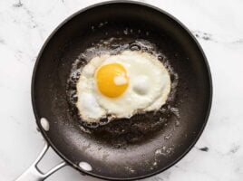 A sunny side egg being fried in a skillet.