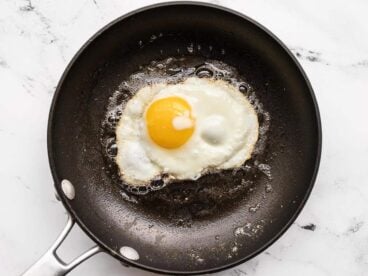 A sunny side egg being fried in a skillet.