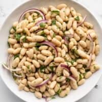 Overhead view of a bowl of lemony white bean salad.