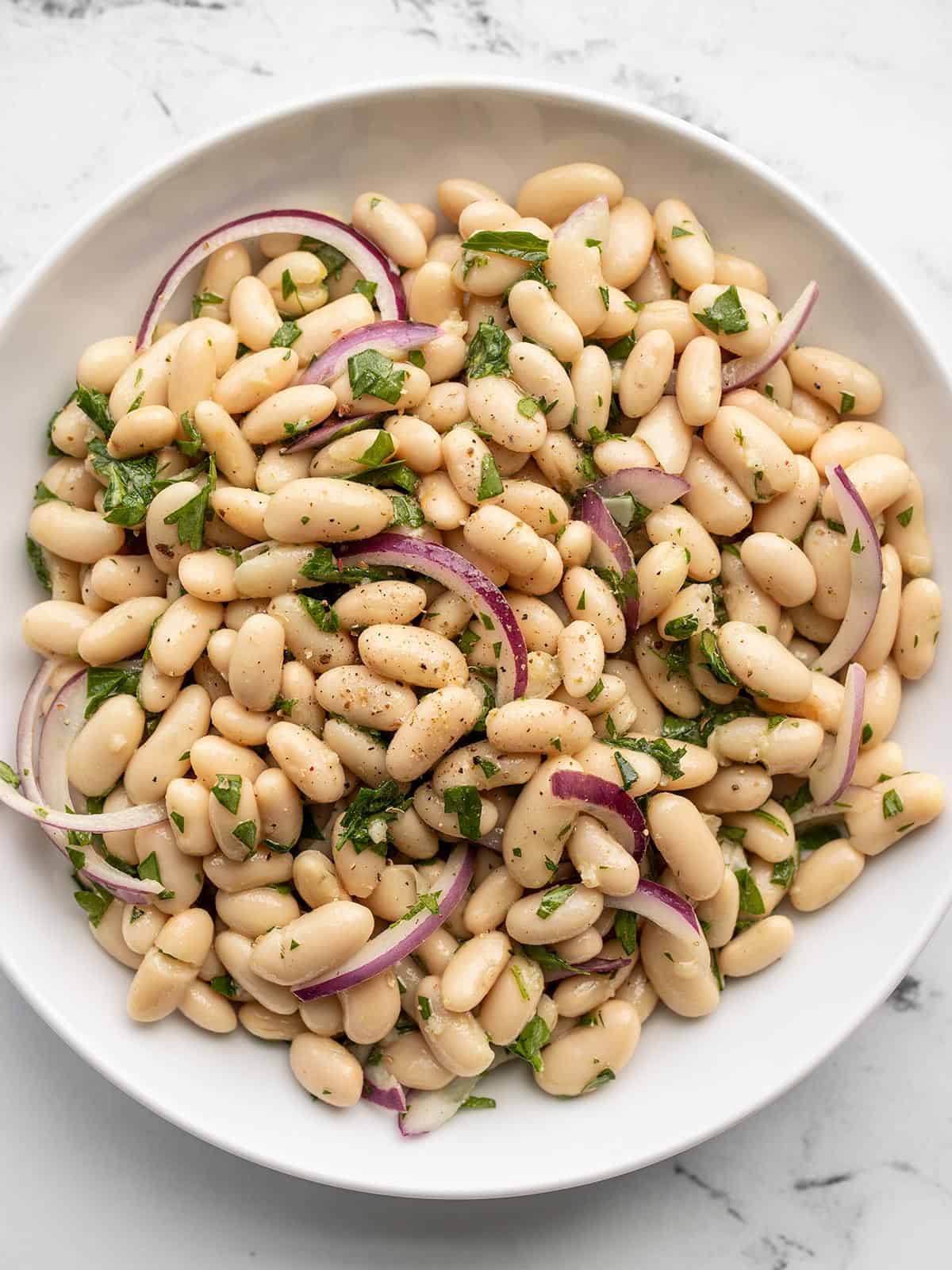 Overhead view of lemony white bean salad in a bowl.