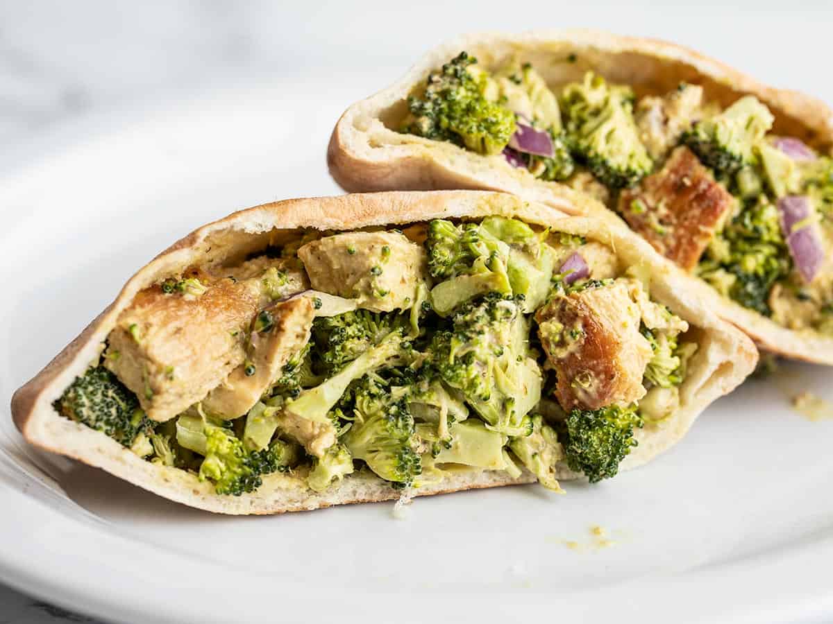 Pesto chicken and broccoli salad in pita pockets on a plate.