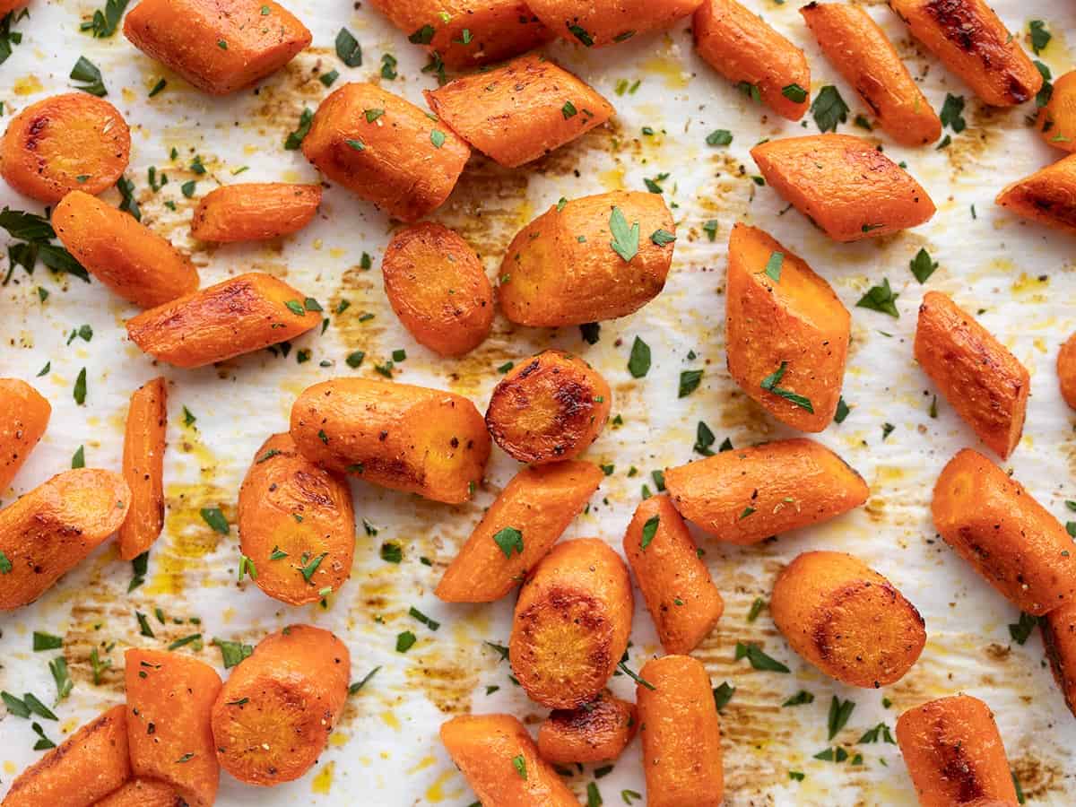 Roasted carrots garnished on a baking sheet.