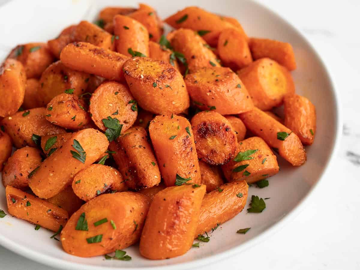 Side view of roasted carrots in a bowl.