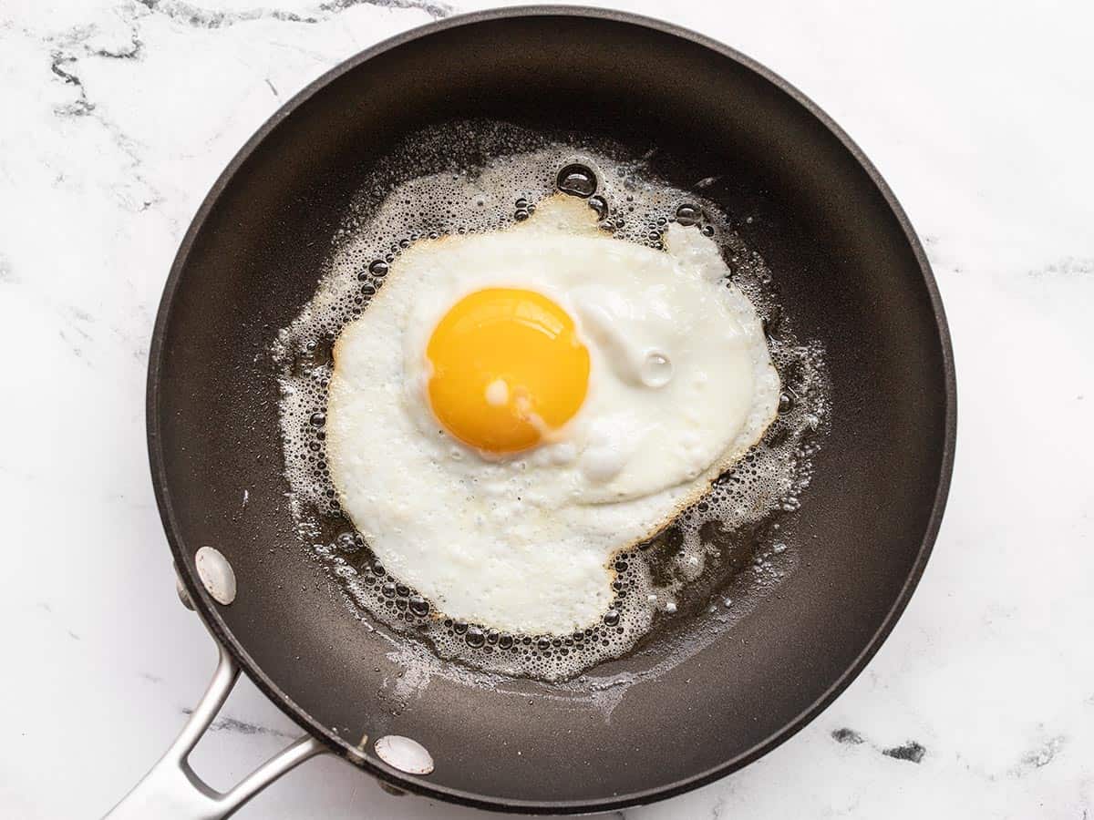 Um ovo ensolarado sendo frito na manteiga