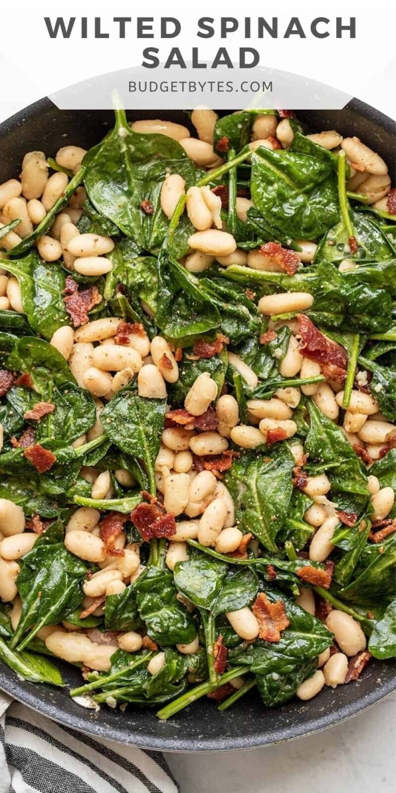 Close up overhead view of wilted spinach salad in the skillet.