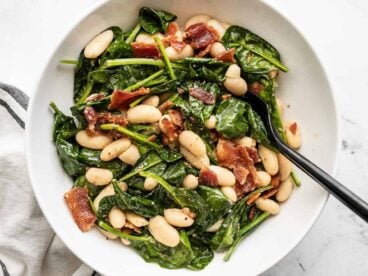 Close up overhead view of a bowl of wilted spinach salad.