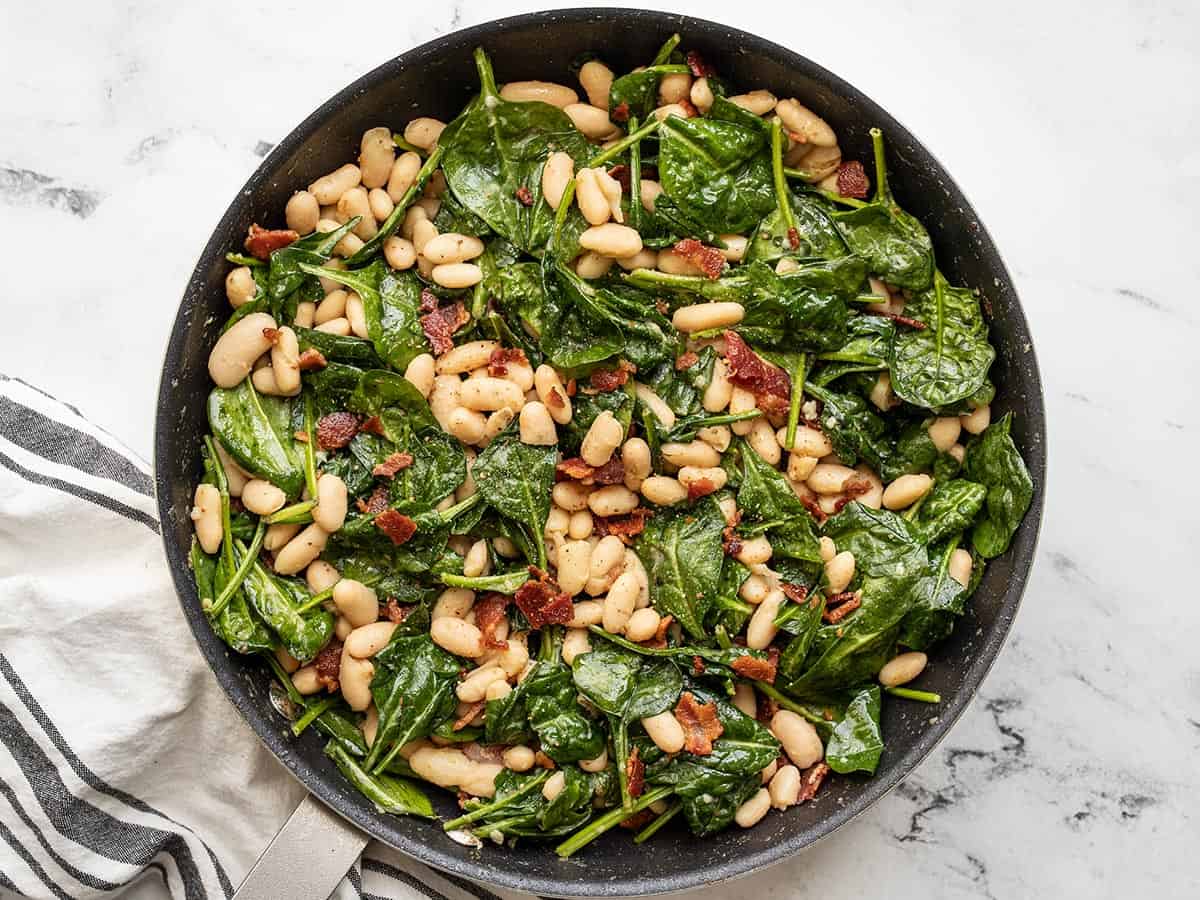 Finished wilted spinach salad in the skillet.