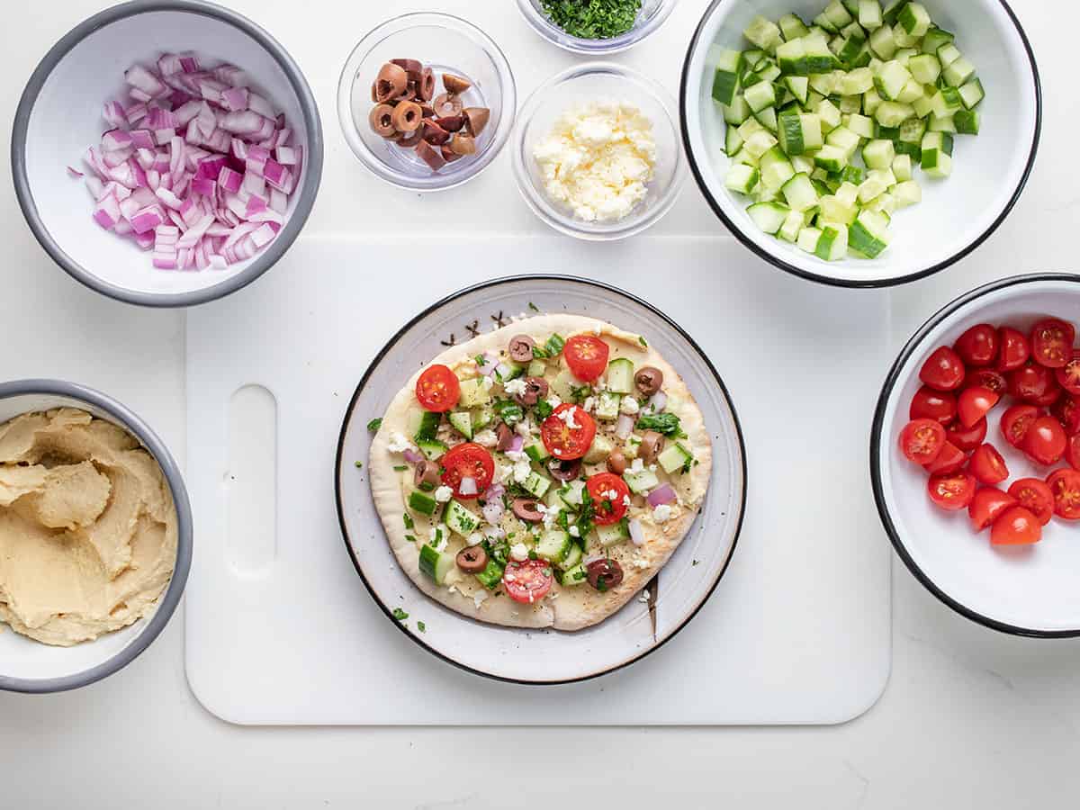 Pitas loaded with feta cheese, kalamata olives, and a sprinkle of chopped parsley.