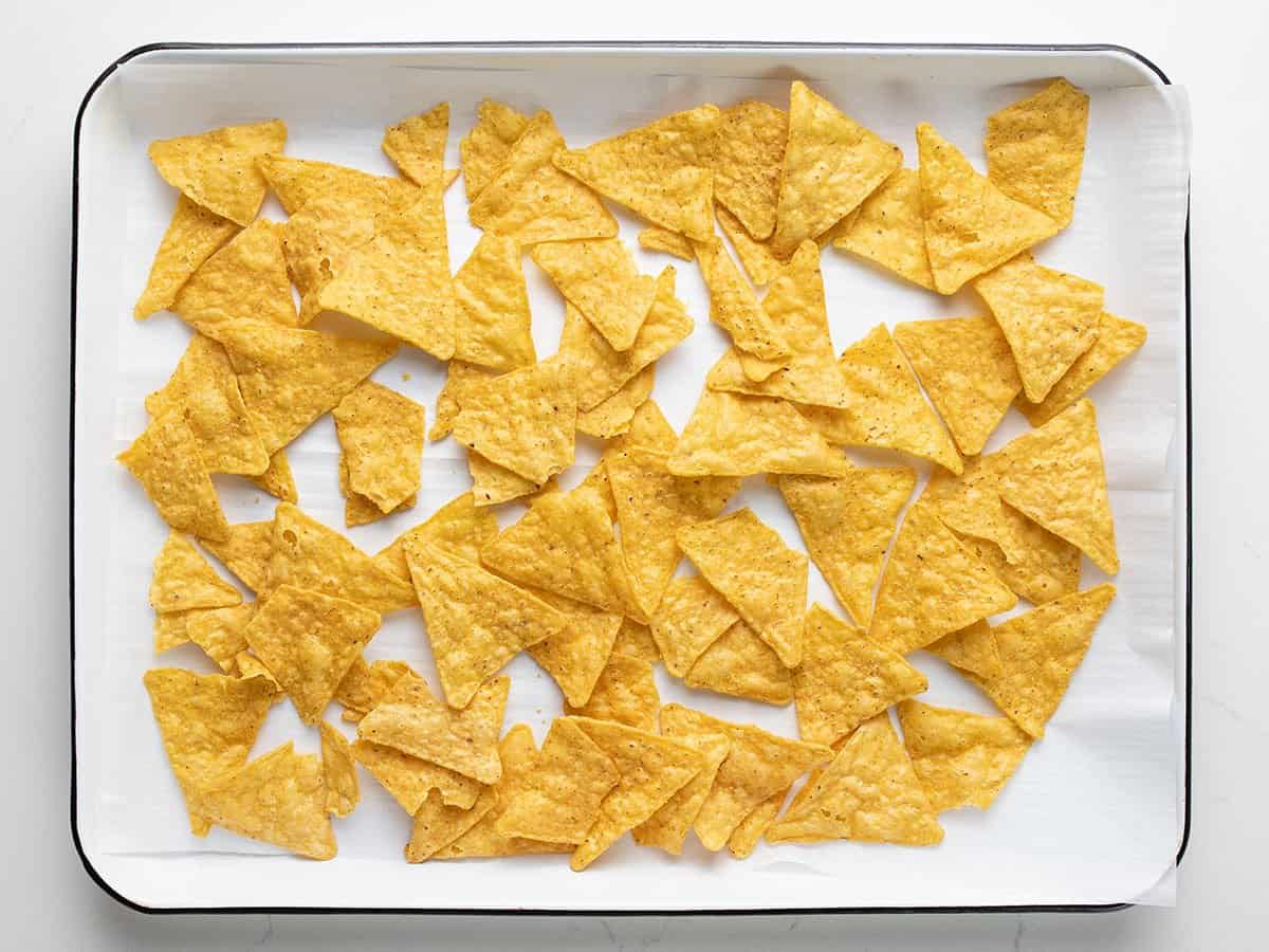 tortilla chips on a lined baking sheet.