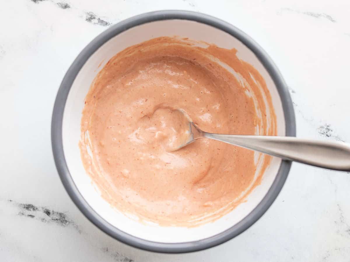 creamy tomato sauce in a bowl with a spoon.